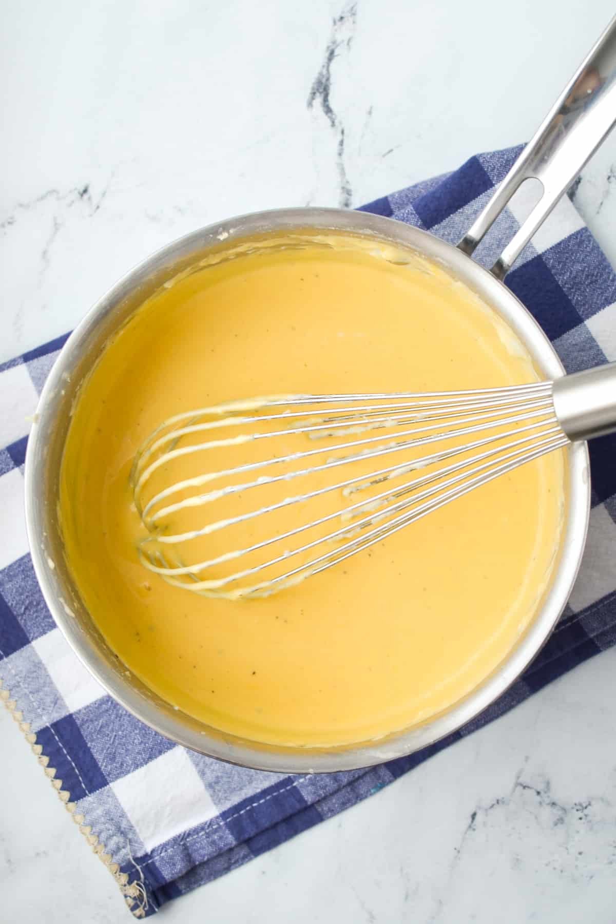 A saucepan filled with cheese sauce.