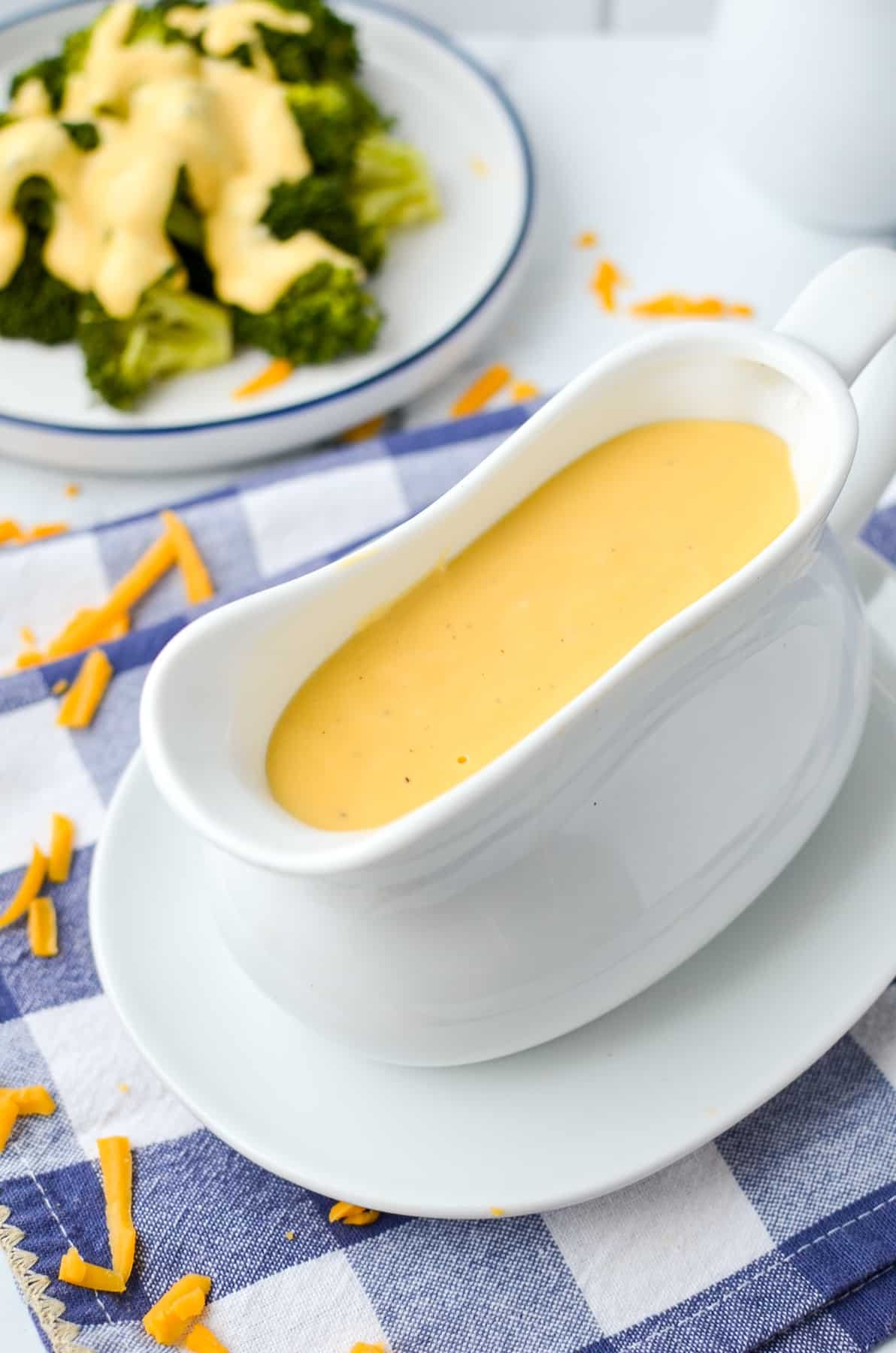 A gravy boat filled with cheese sauce.