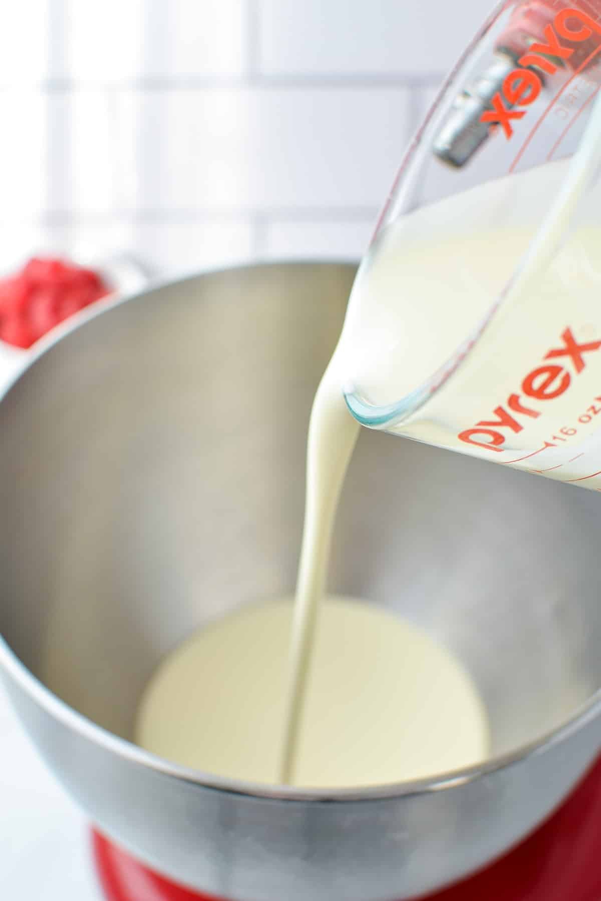 Pouring heavy cream into a bowl.