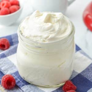 A jar filled with fluffy homemade whipped cream.