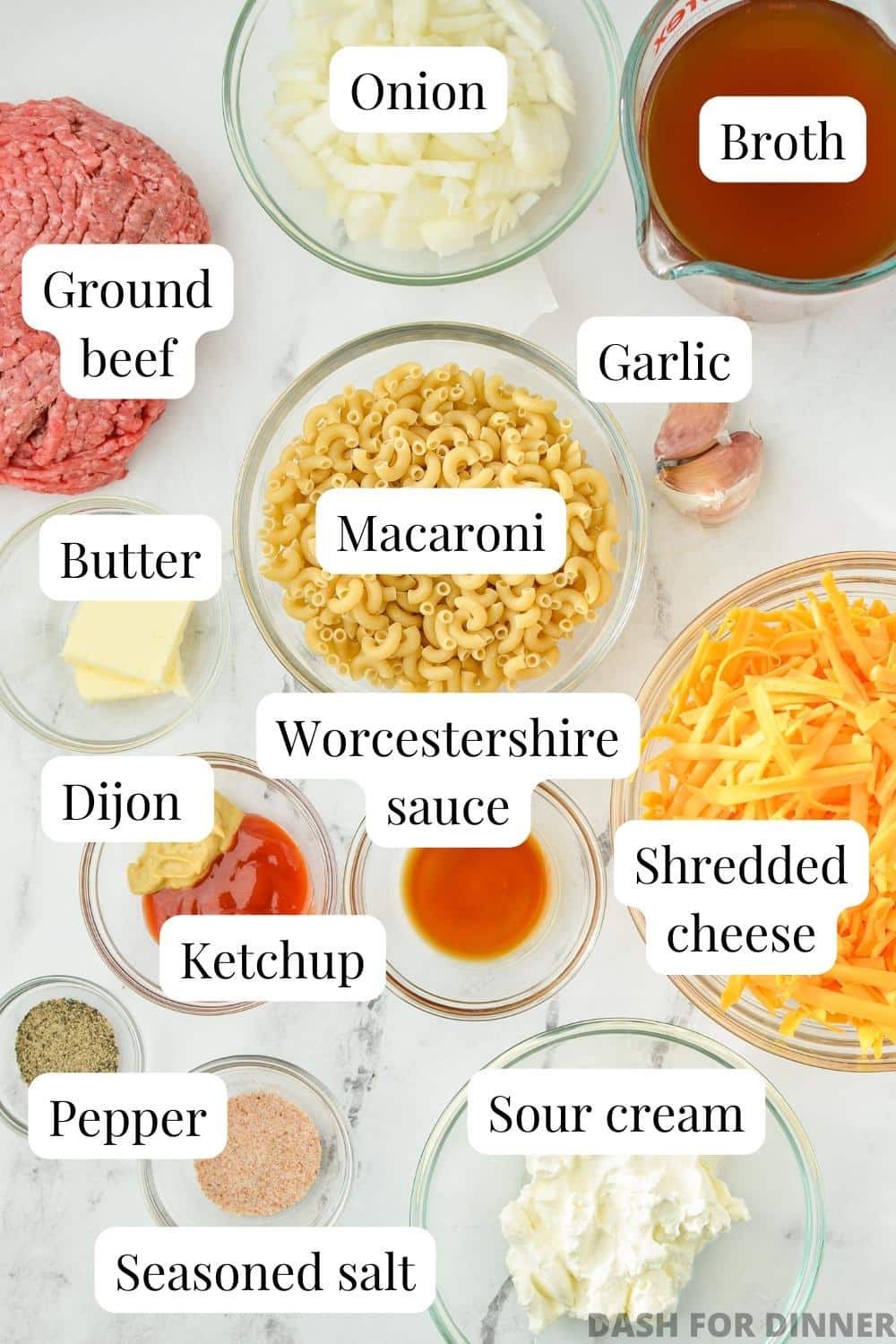 The ingredients needed to make homemade cheeseburger macaroni, including pasta, ground beef, cheese, and broth.