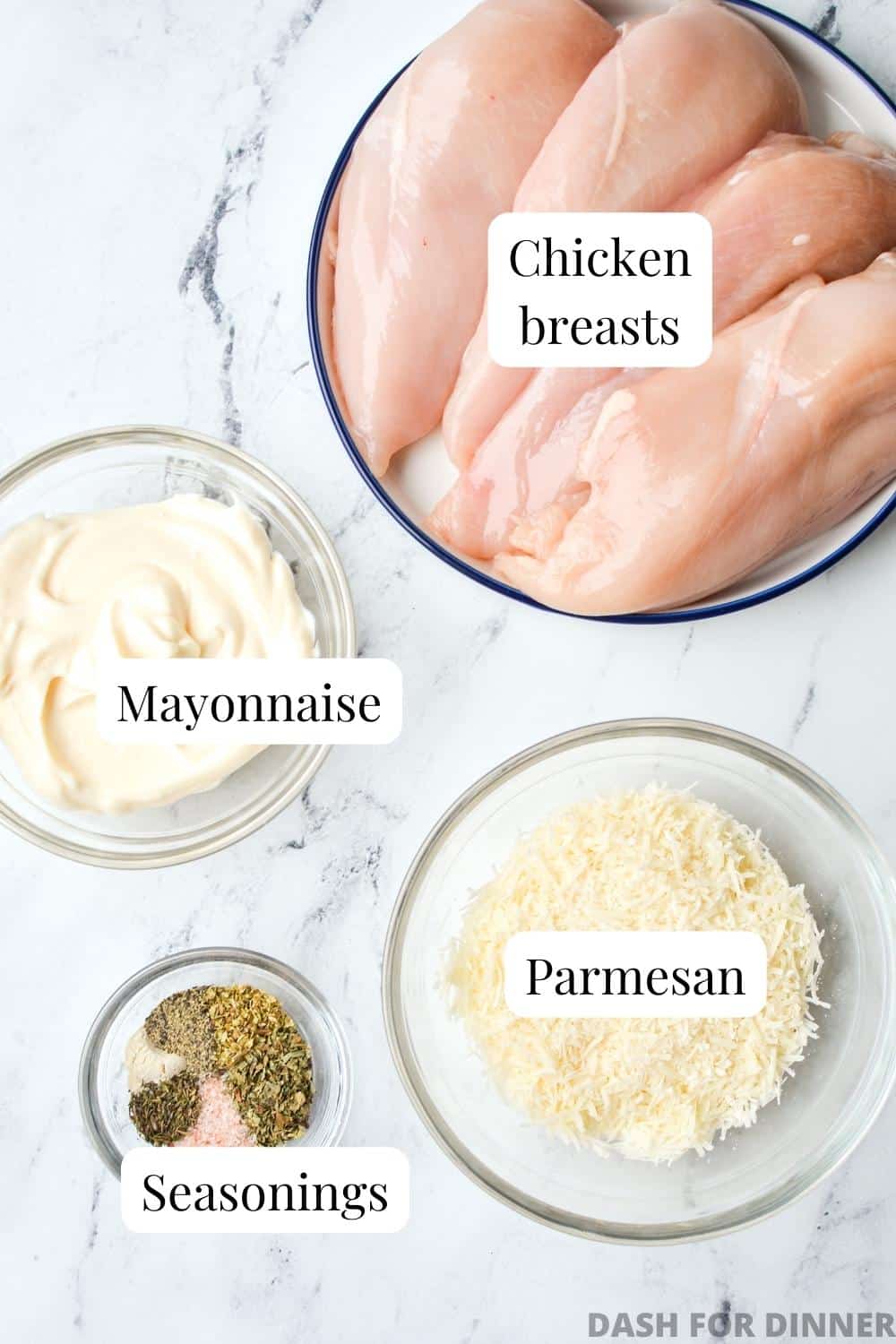 The ingredients needed to make Mayo Parmesan Chicken: chicken breasts, mayonnaise, herbs and seasonings, and parmesan cheese.
