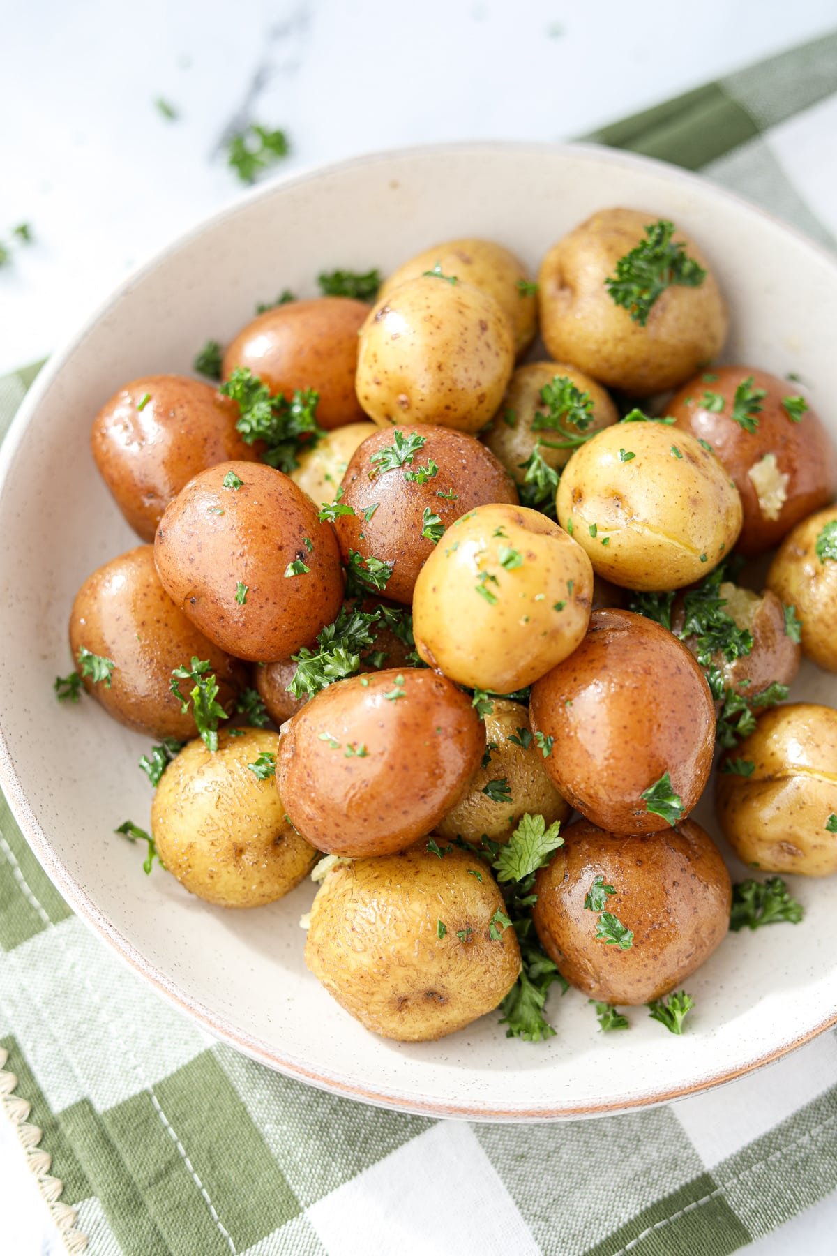 A bowl of little potatoes garnished with parsley.
