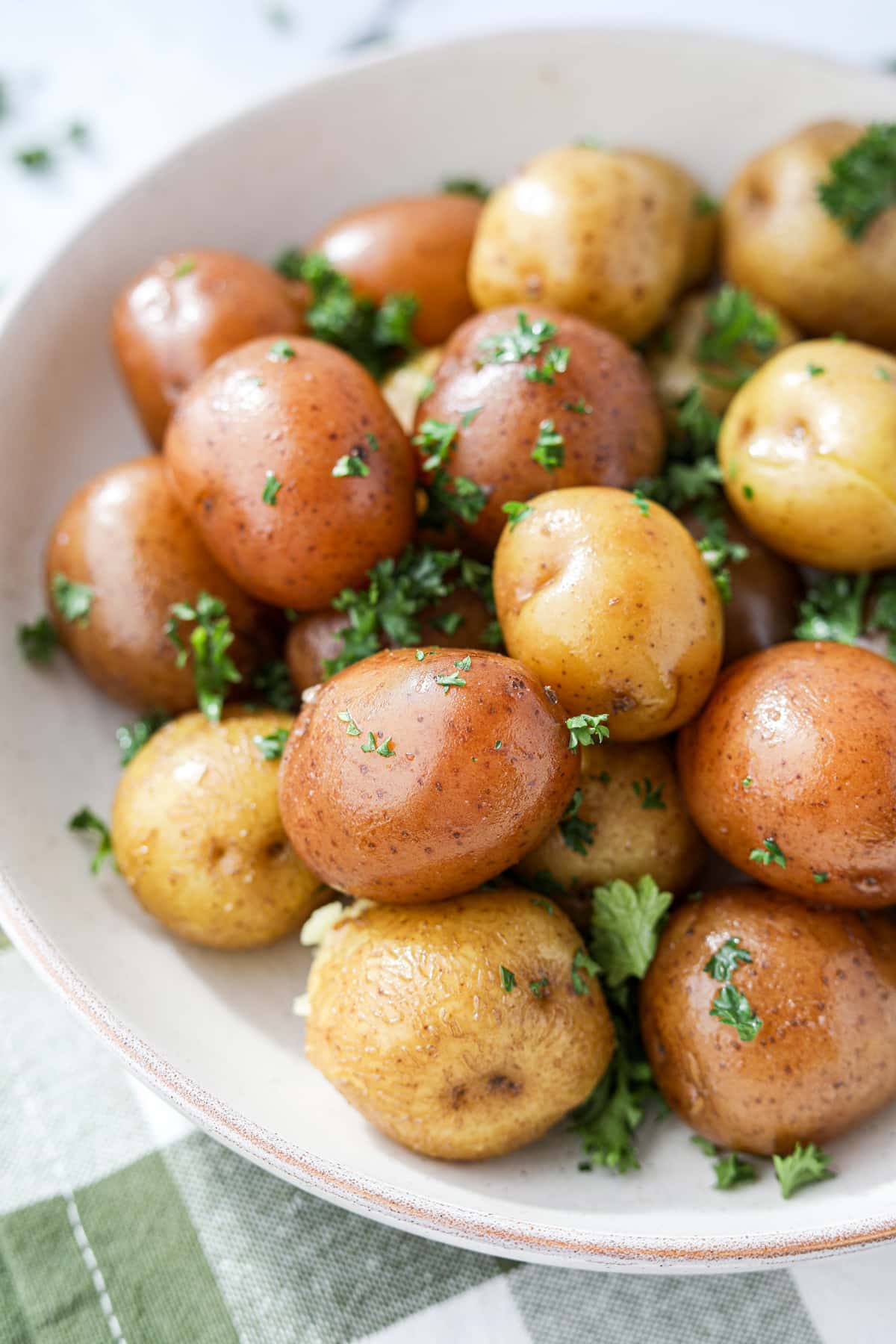 A bowl of steamed small potatoes garnished with parsley.