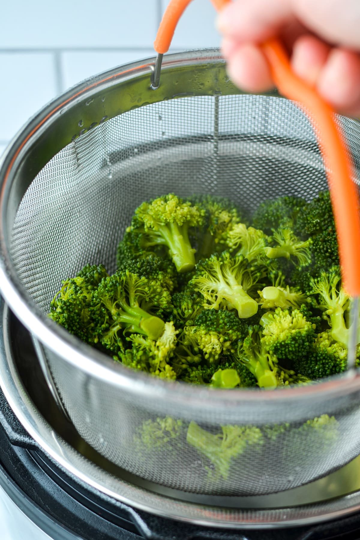 Removing a steamer basket from an Instant Pot.