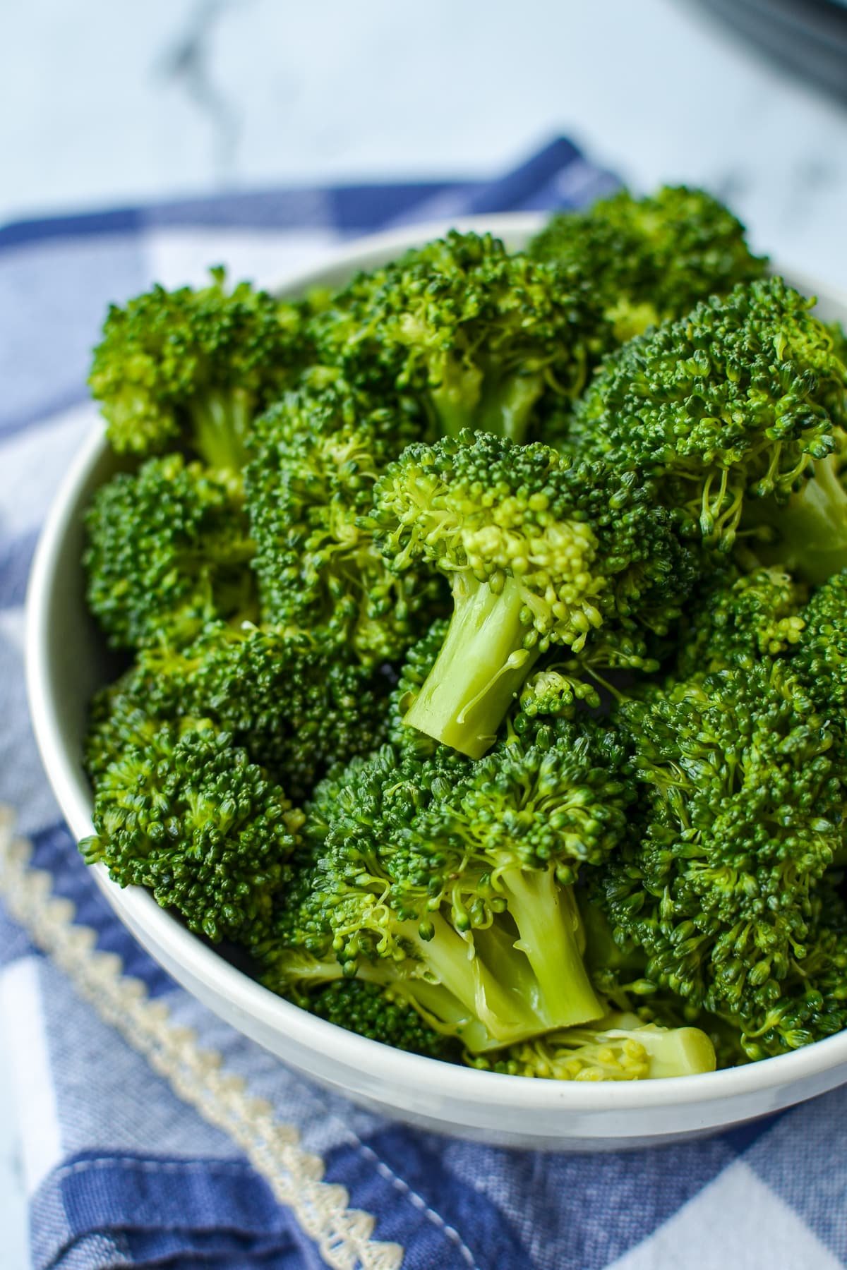 A bowl of tender cooked broccoli.