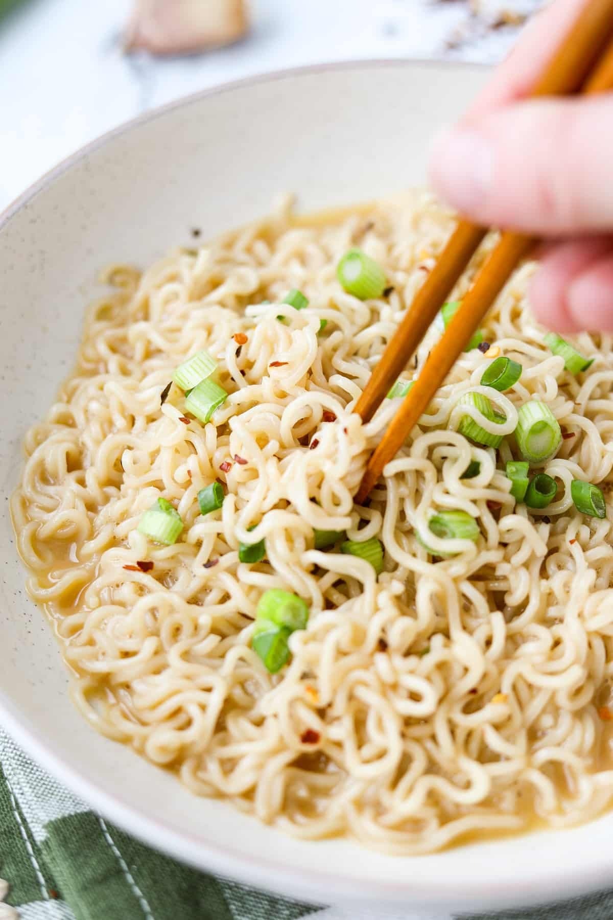 Using chopsticks to pull ramen noodles from a bowl.