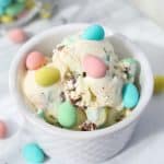 A white bowl filled with ice cream and dotted with Cadbury Mini Eggs.