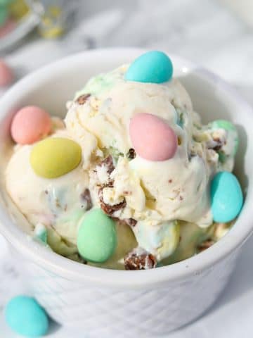 A white bowl filled with ice cream and dotted with Cadbury Mini Eggs.