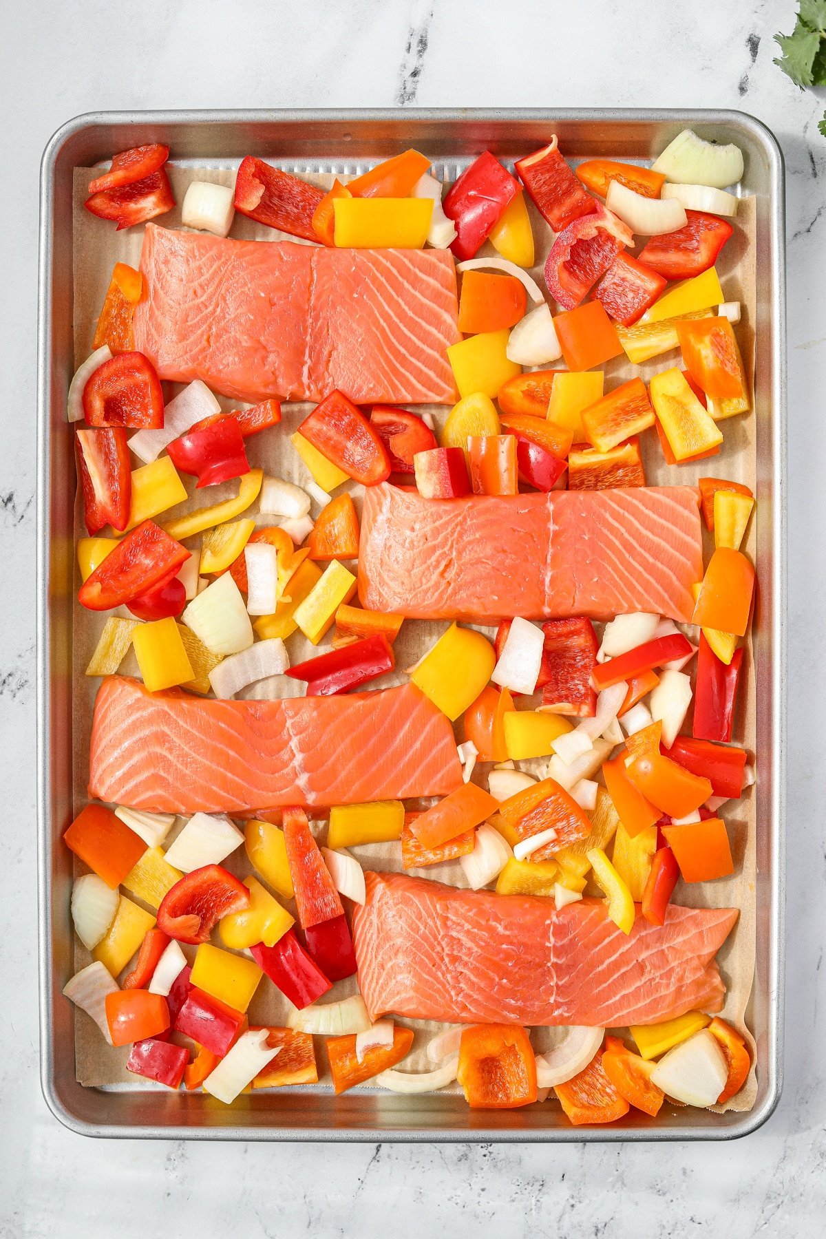 A sheet pan with salmon and veggies on it.