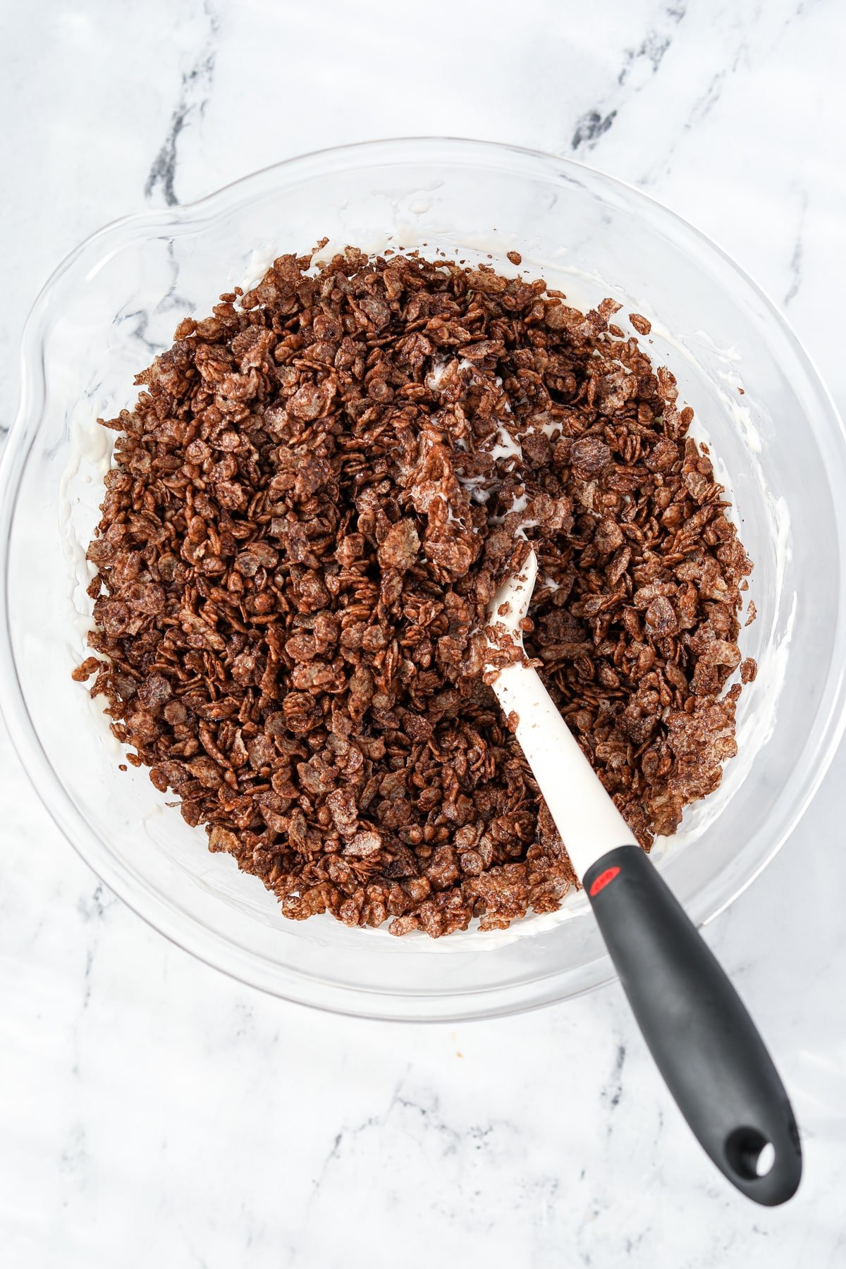 A bowl with crispy cocoa rice added to melted marshmallows.