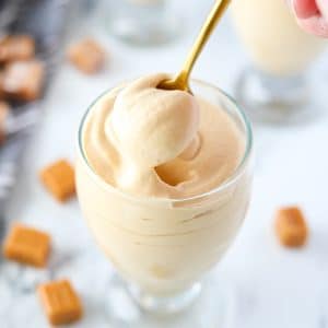 A gold spoon taking a portion of dulce de leche mousse.