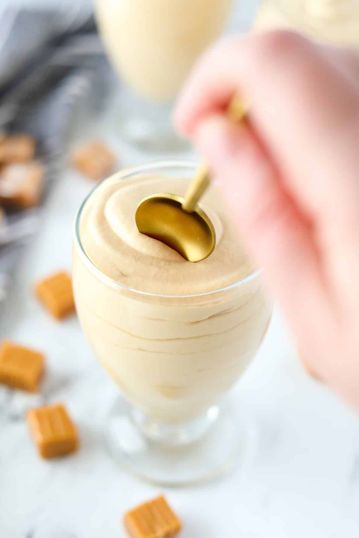 Spooning a small amount of mousse from a dessert glass.