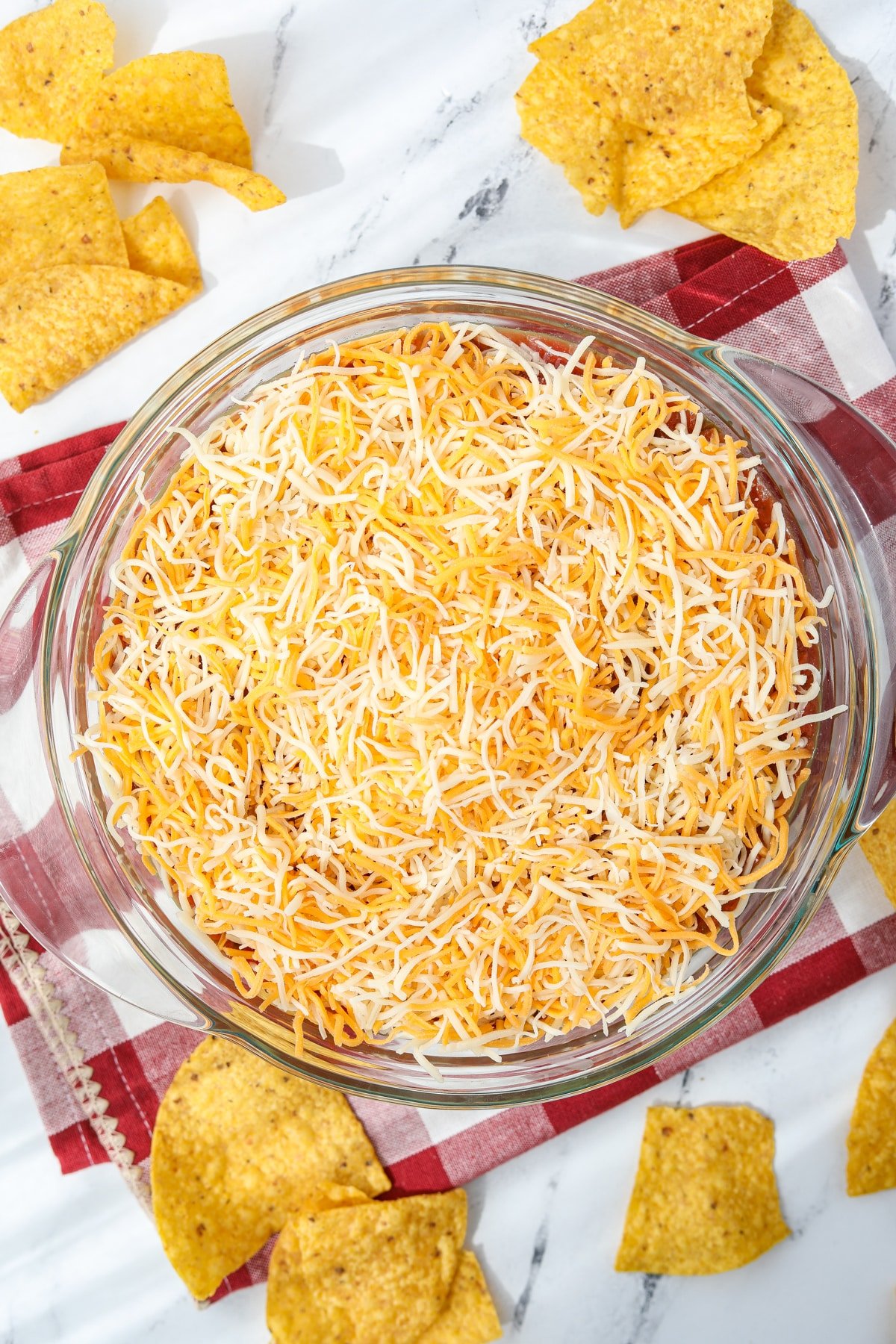 A baking dish covered in shredded cheese.