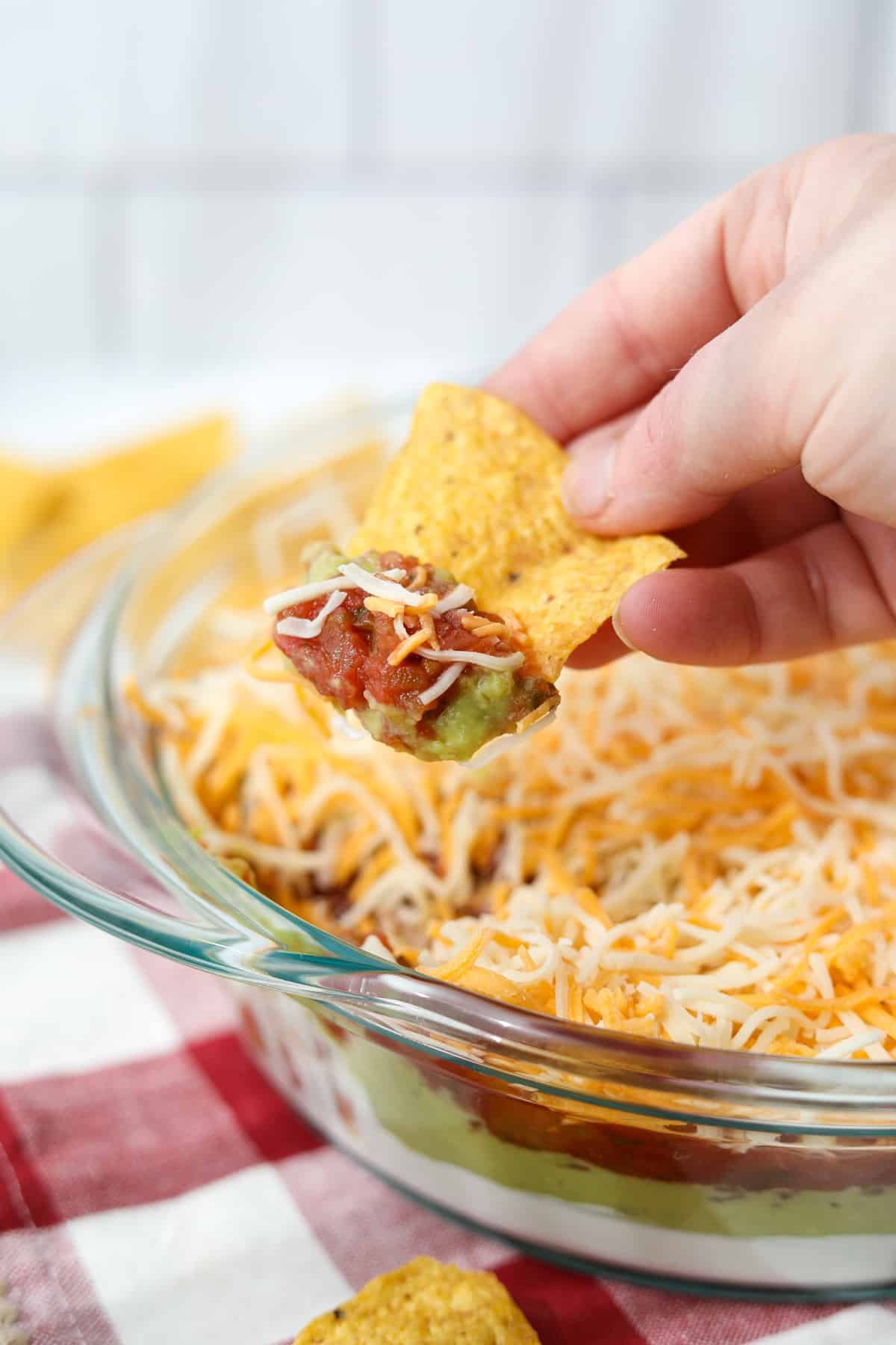 Dipping a tortilla chip into a cold dip.