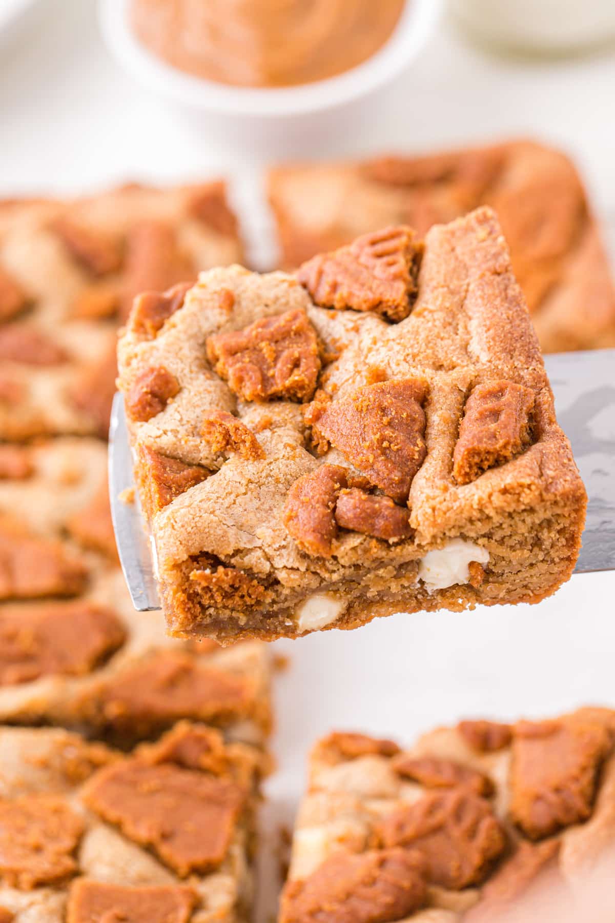 Lifting biscoff blondies from a pan.