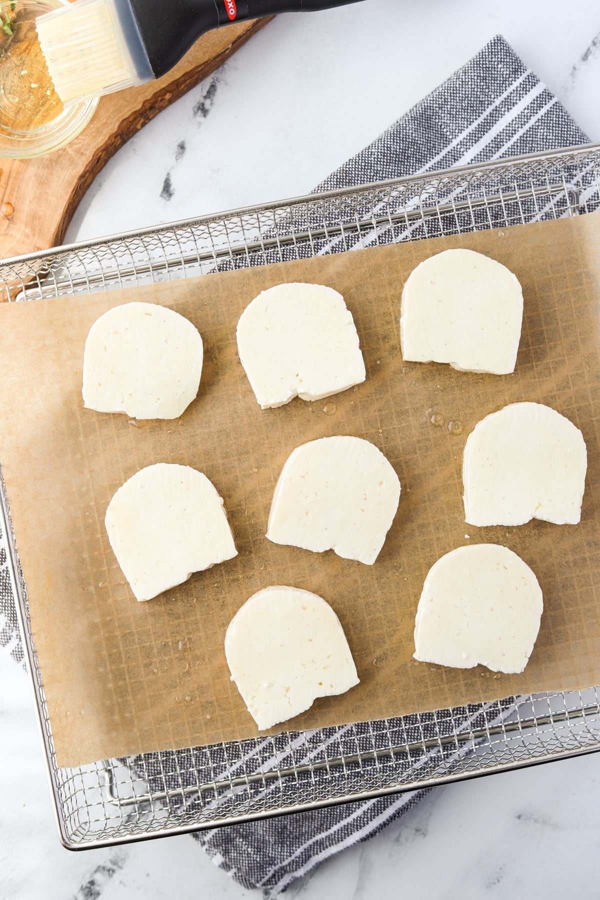 An air fryer tray with halloumi cheese slices.