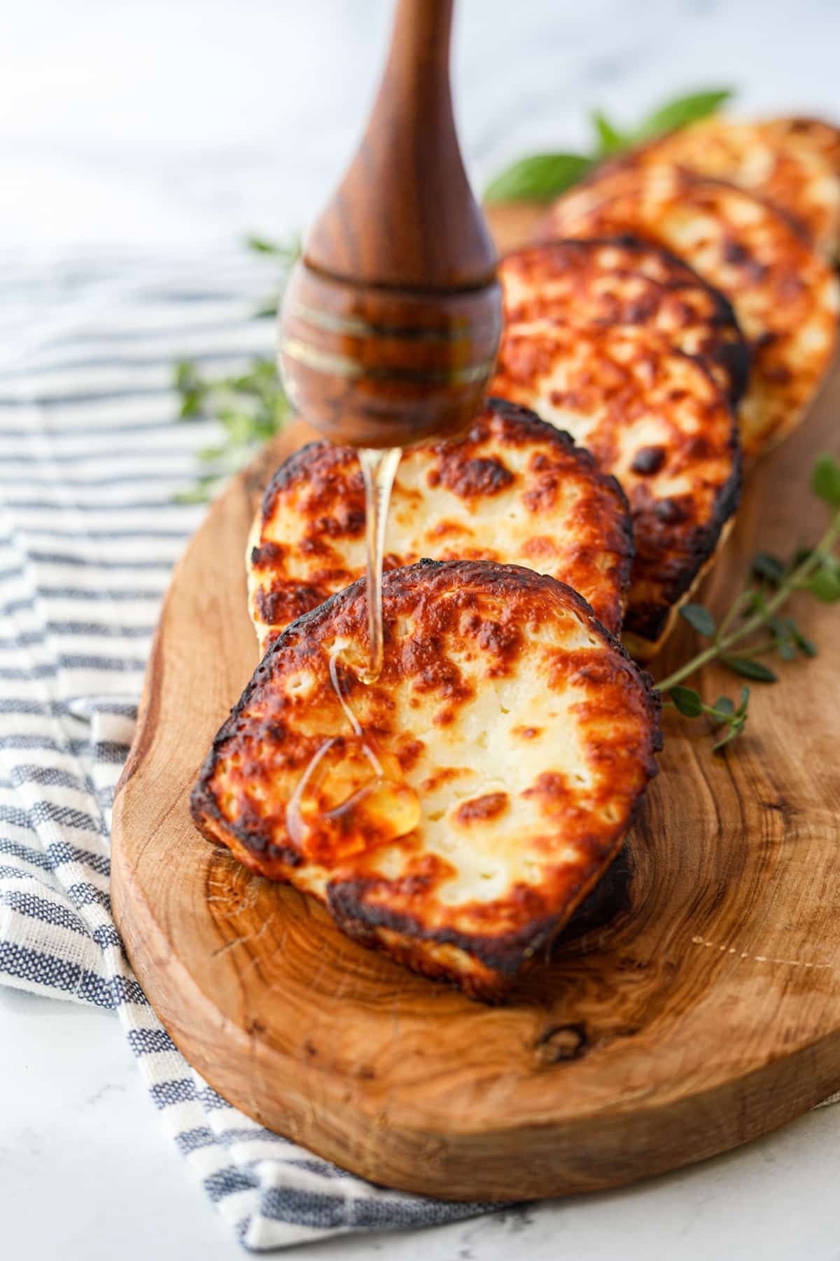 Drizzling honey on fried cheese.