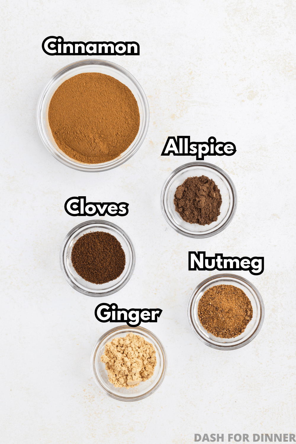 Small bowls of cinnamon, cloves, allspice, nutmeg, and ginger.