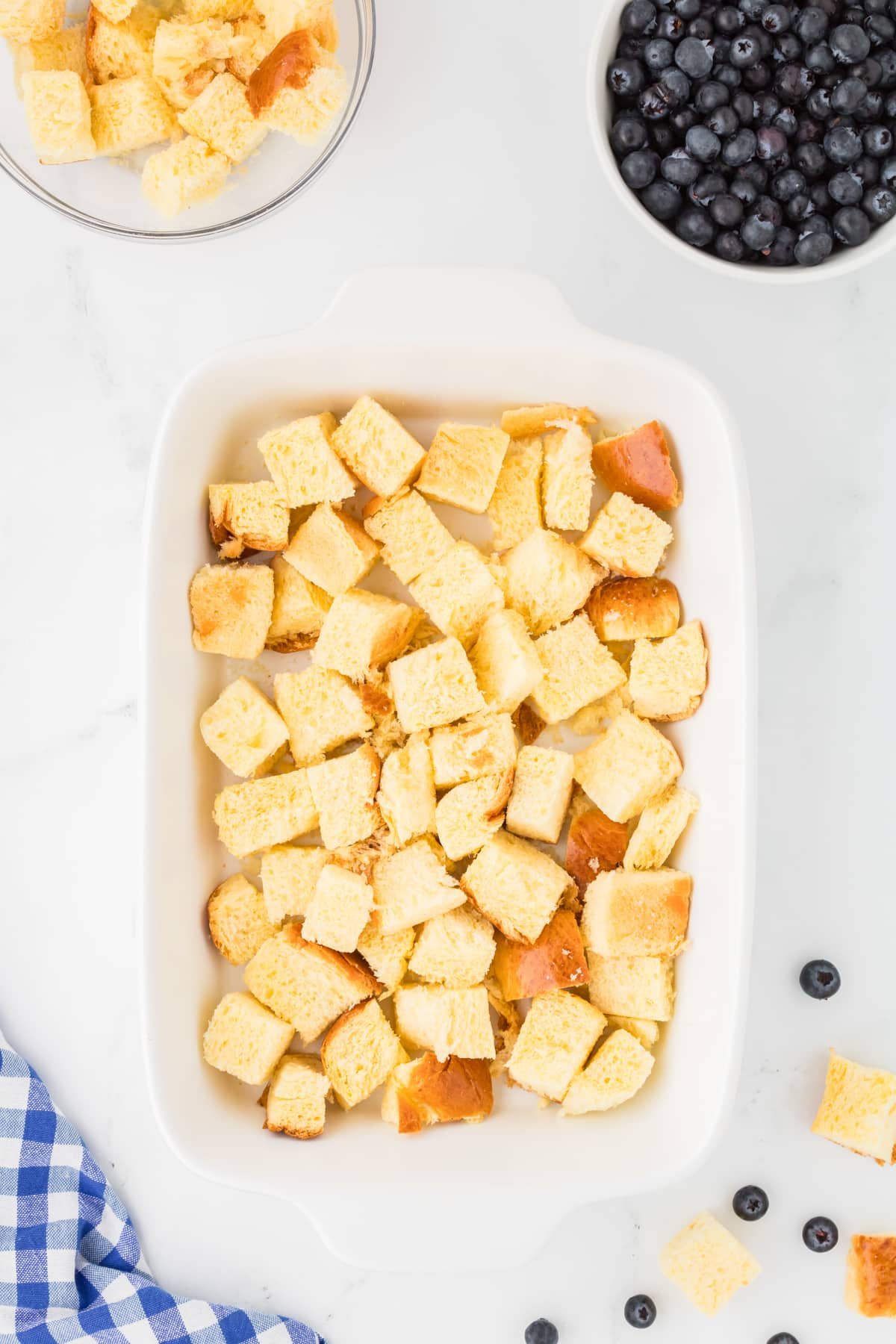 A baking dish with cubed bread in it.