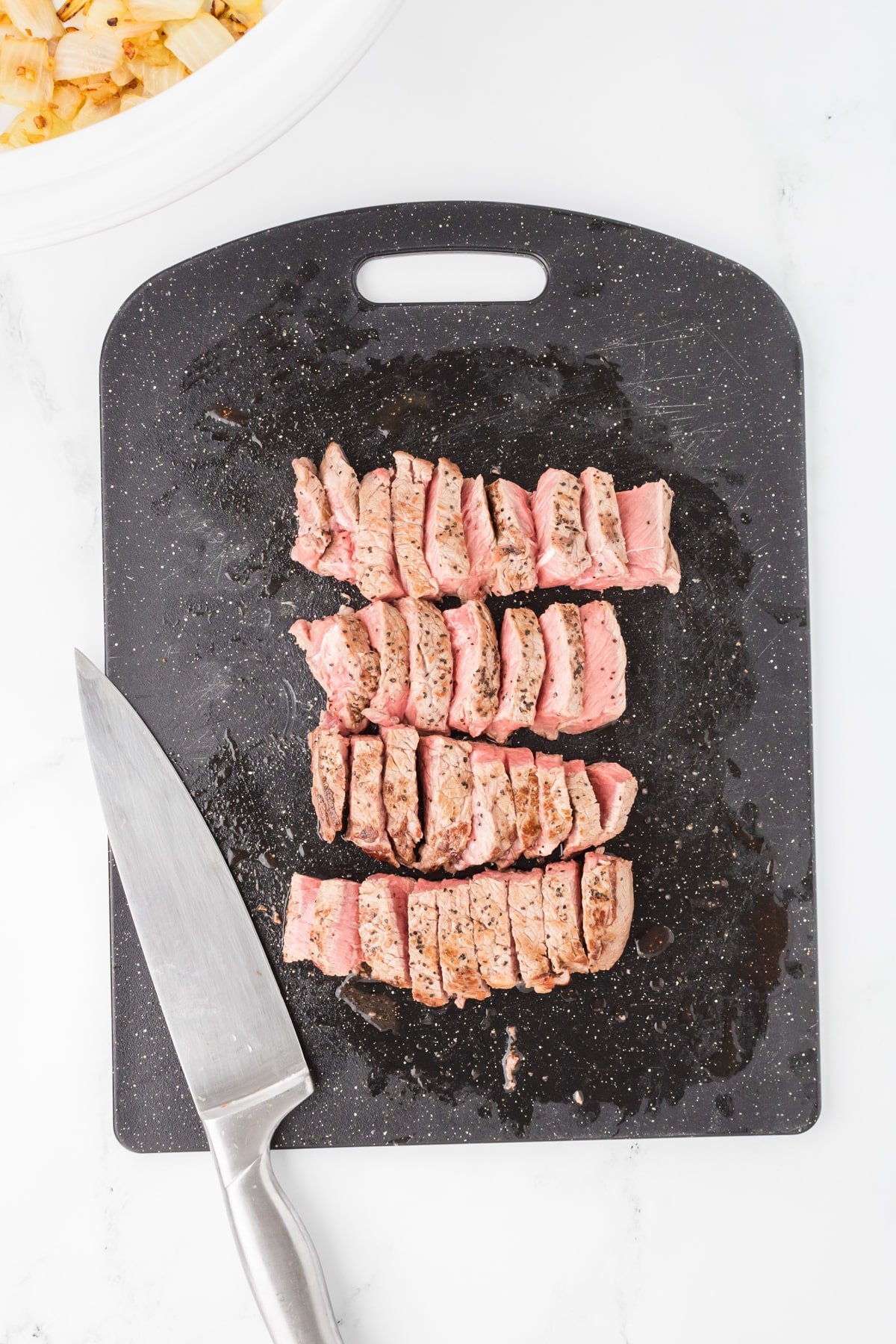 A cutting board with beef cut into strips.