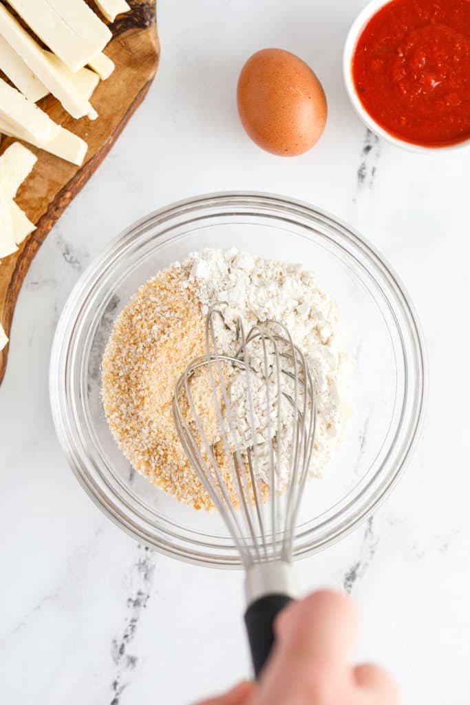 Whisking together flour and breadcrumbs.