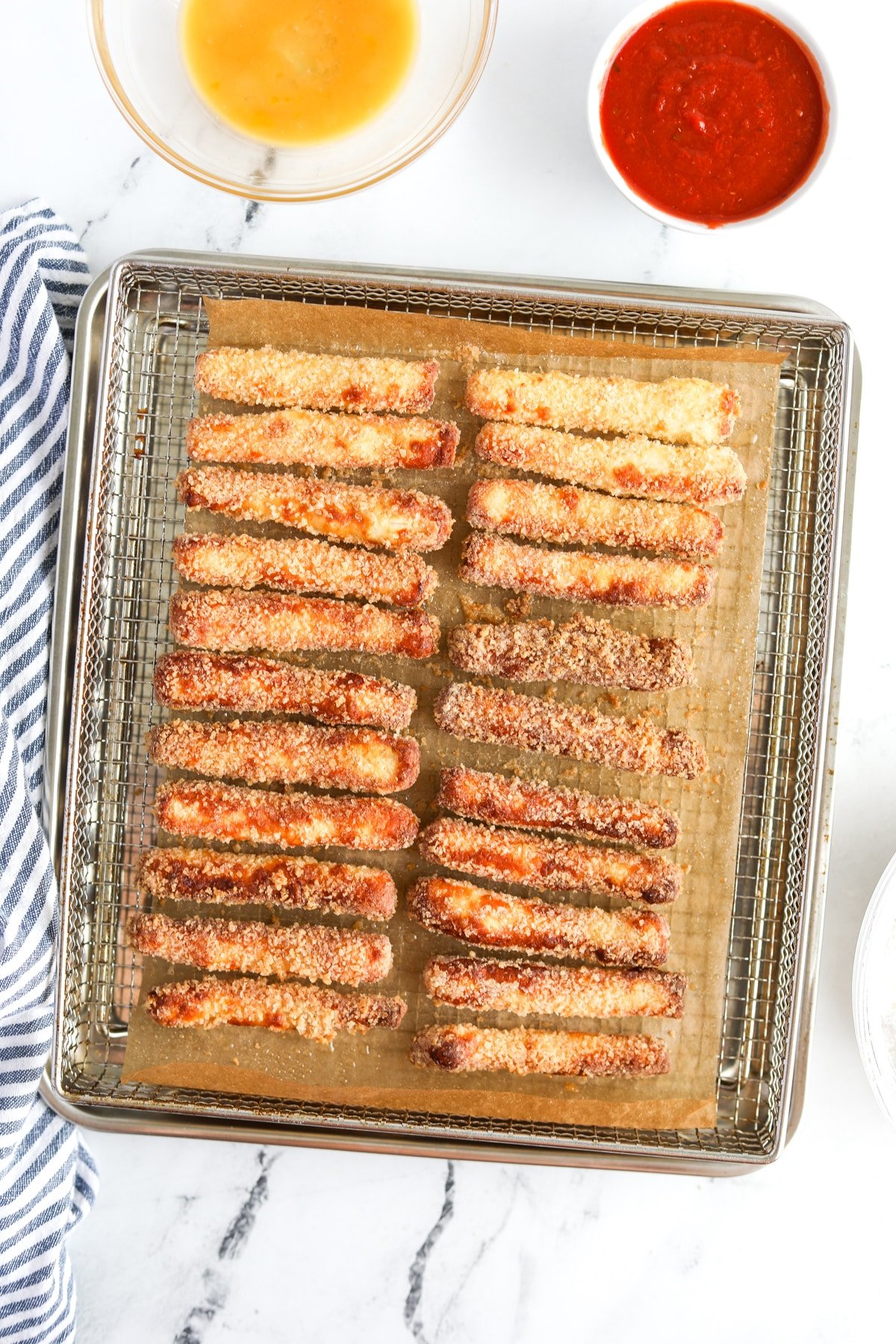 An air fryer tray filled with crispy halloumi fries.