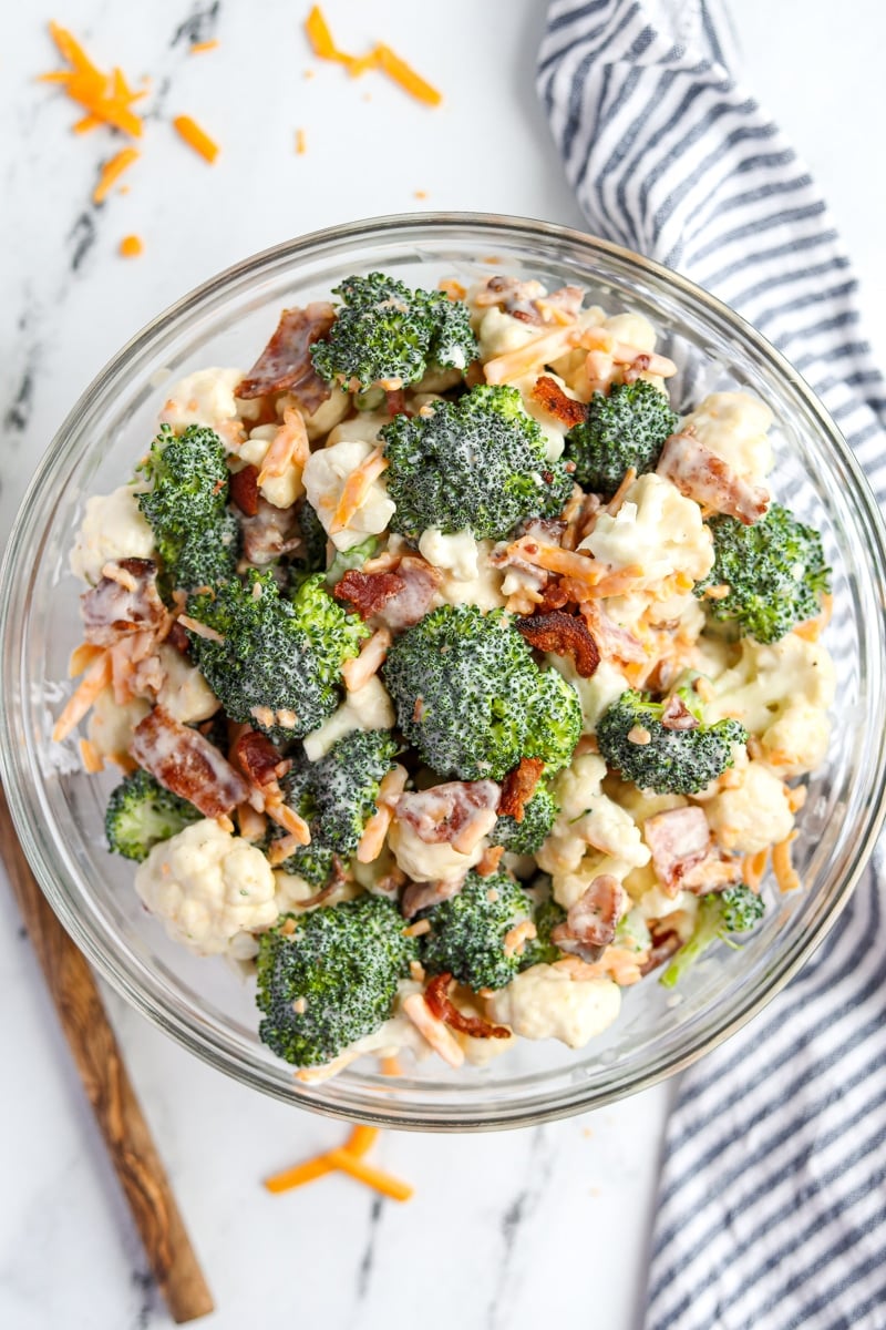 A bowl of broccoli salad with cauliflower, bacon and cheese.