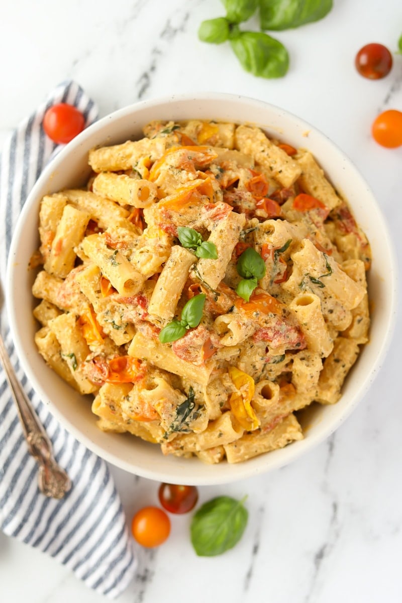 A bowl of pasta garnished with fresh basil.