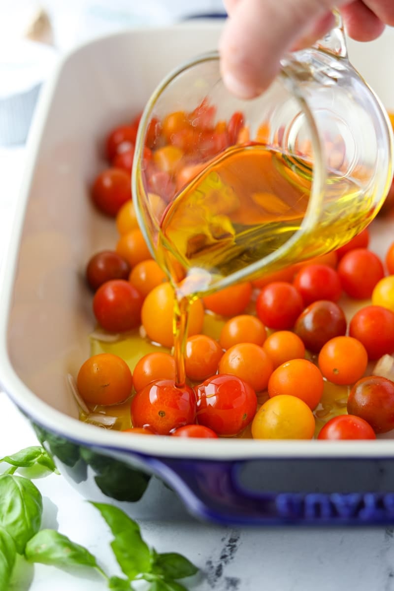 Drizzling olive oil over cherry tomatoes.