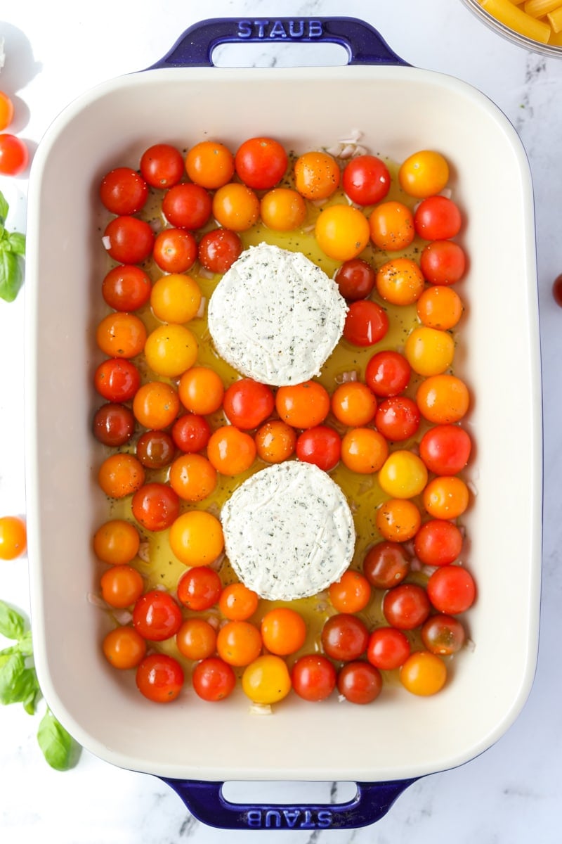 A baking dish filled with cherry tomatoes and Boursin cheese.