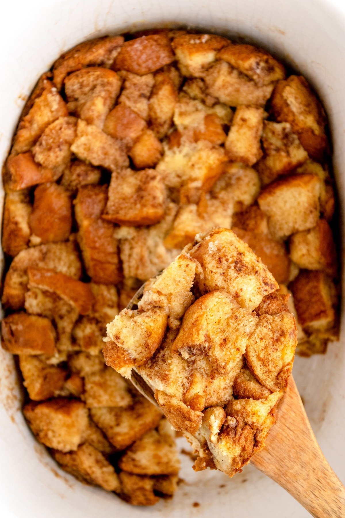 Lifting French toast casserole from a slow cooker.