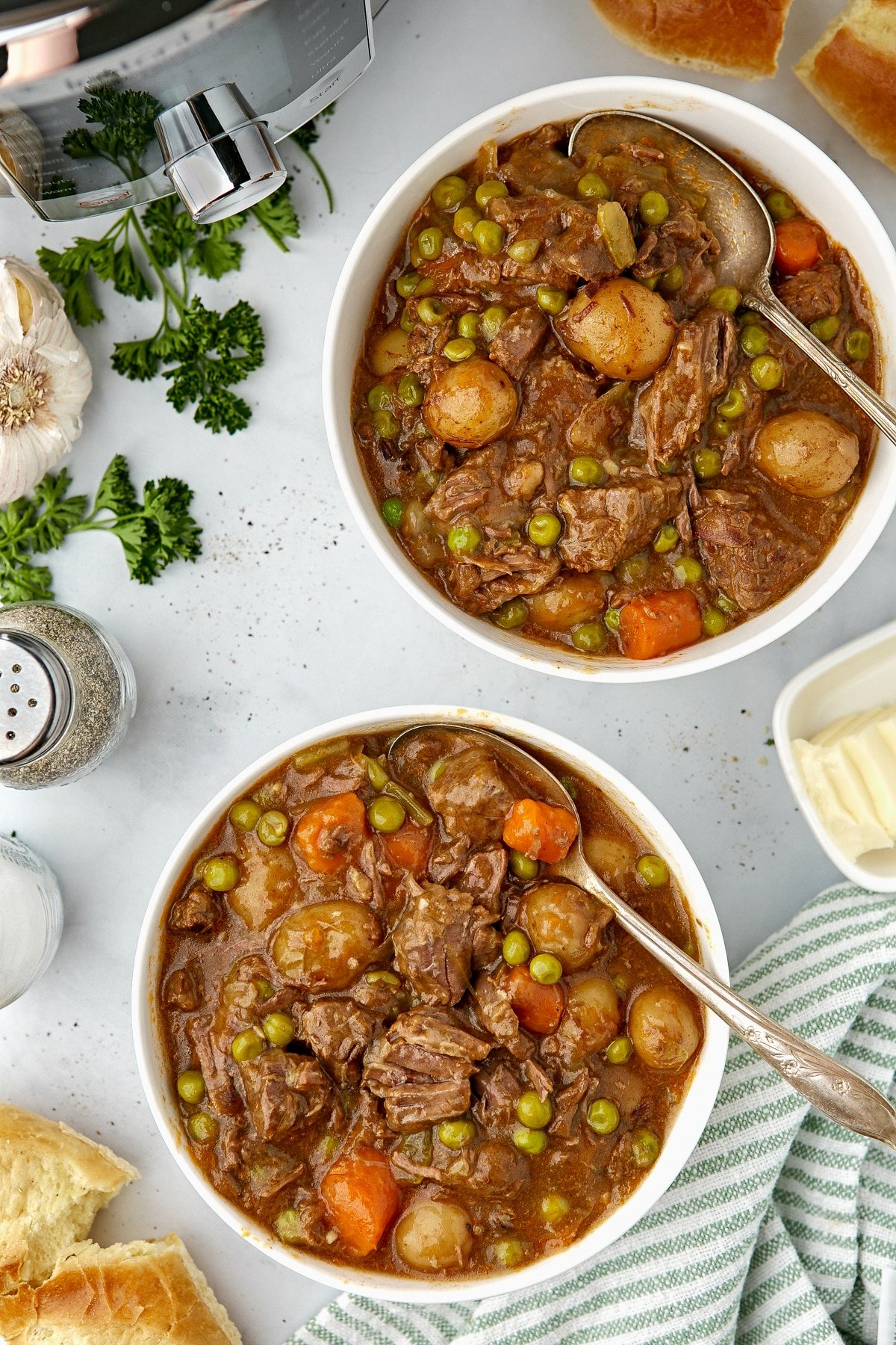 Two bowls of beef stew on a countertop.