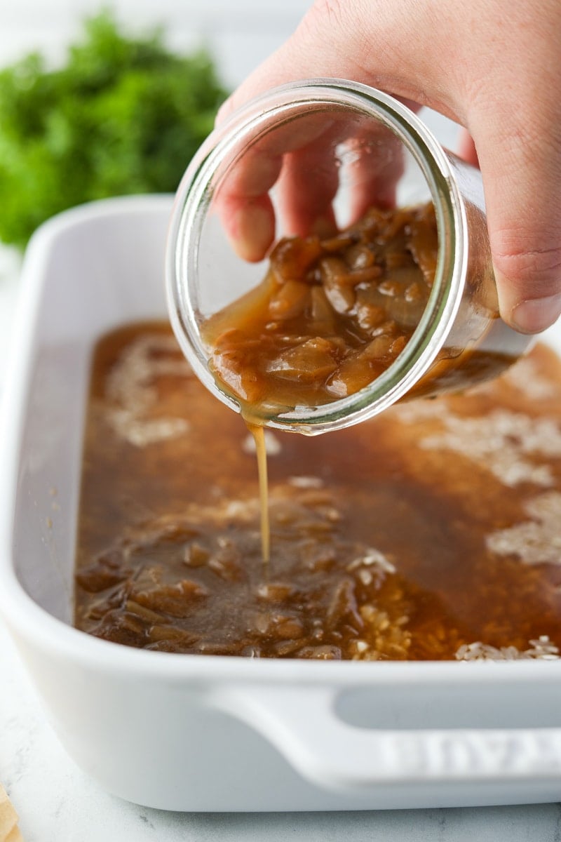 Pouring onion soup into a baking dish.