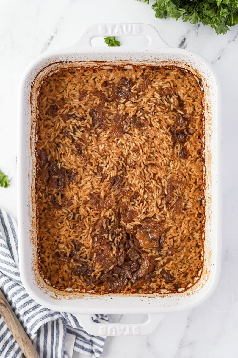 A baking dish filled with cooked rice and onions.