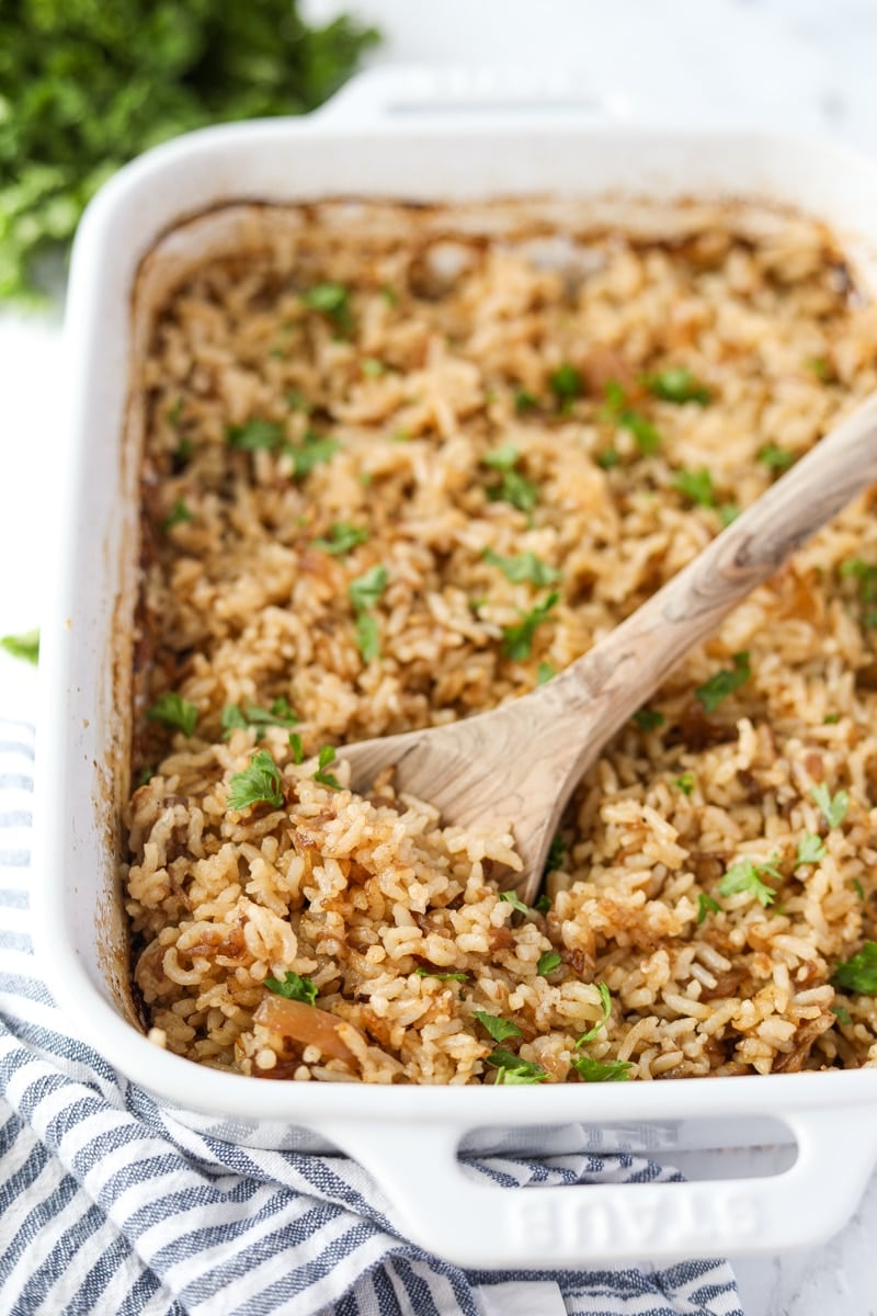 A casserole dish filled rice and garnished with parsley.