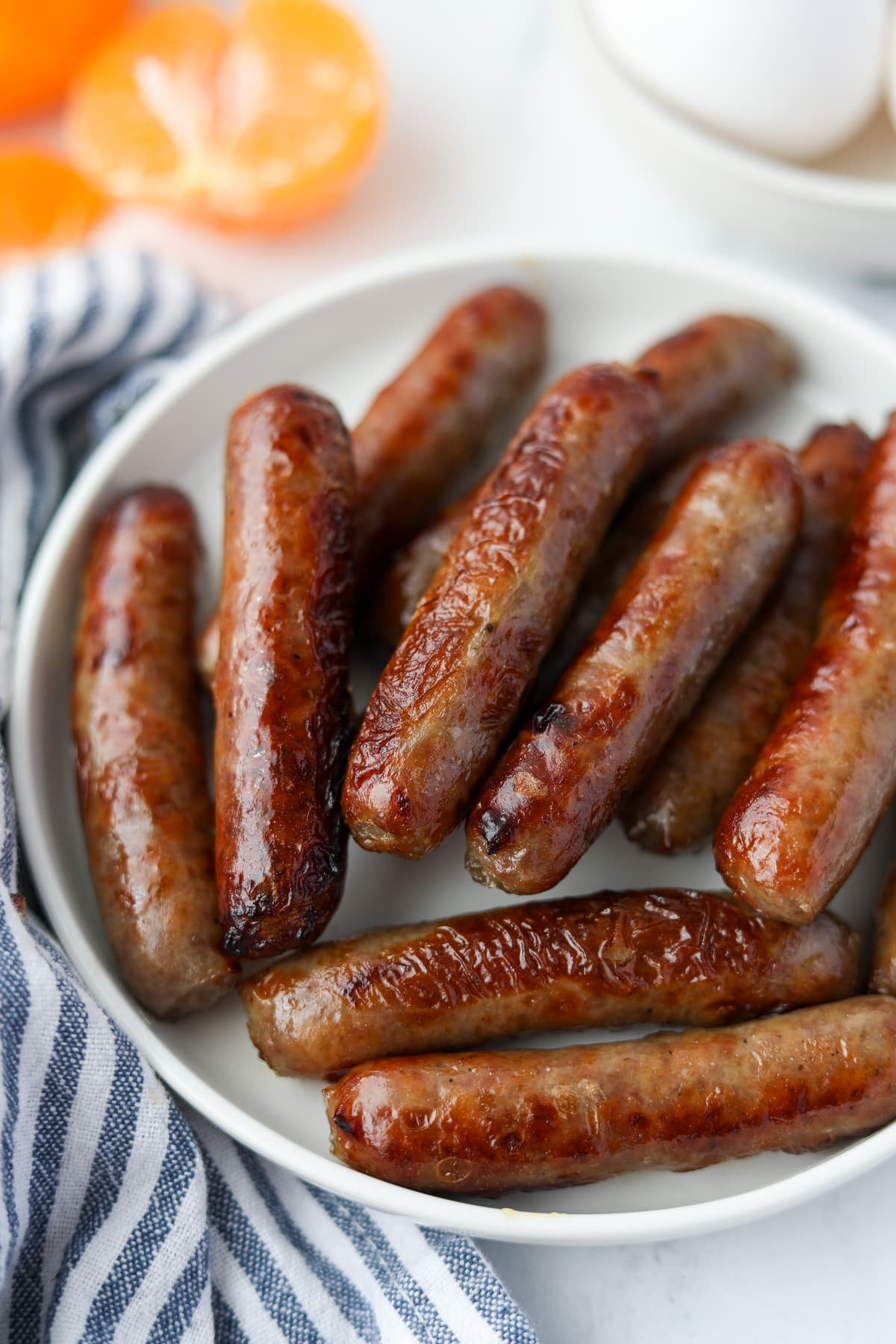 A plate of cooked breakfast sausages.