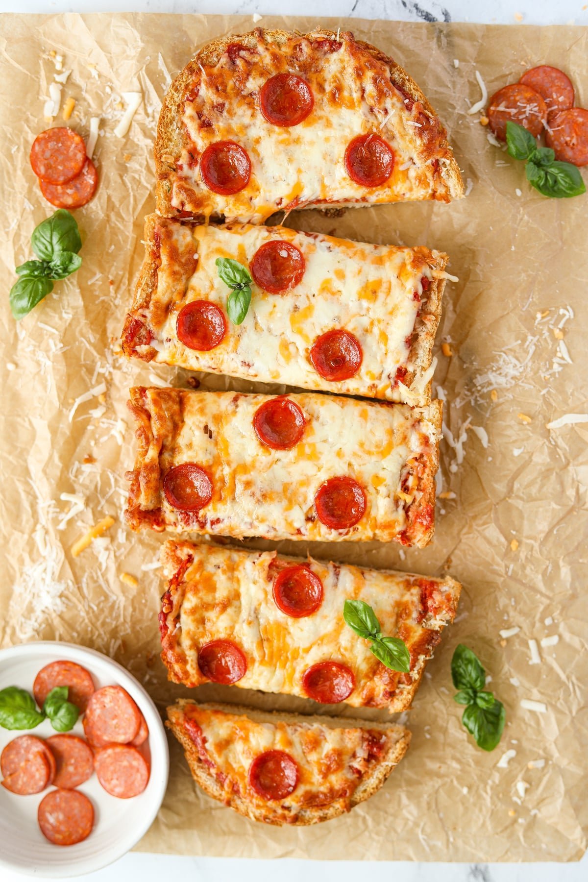 Pizza bread cut into slices on a baking sheet.