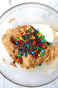 Adding candies and chocolate to a protein cookie dough.