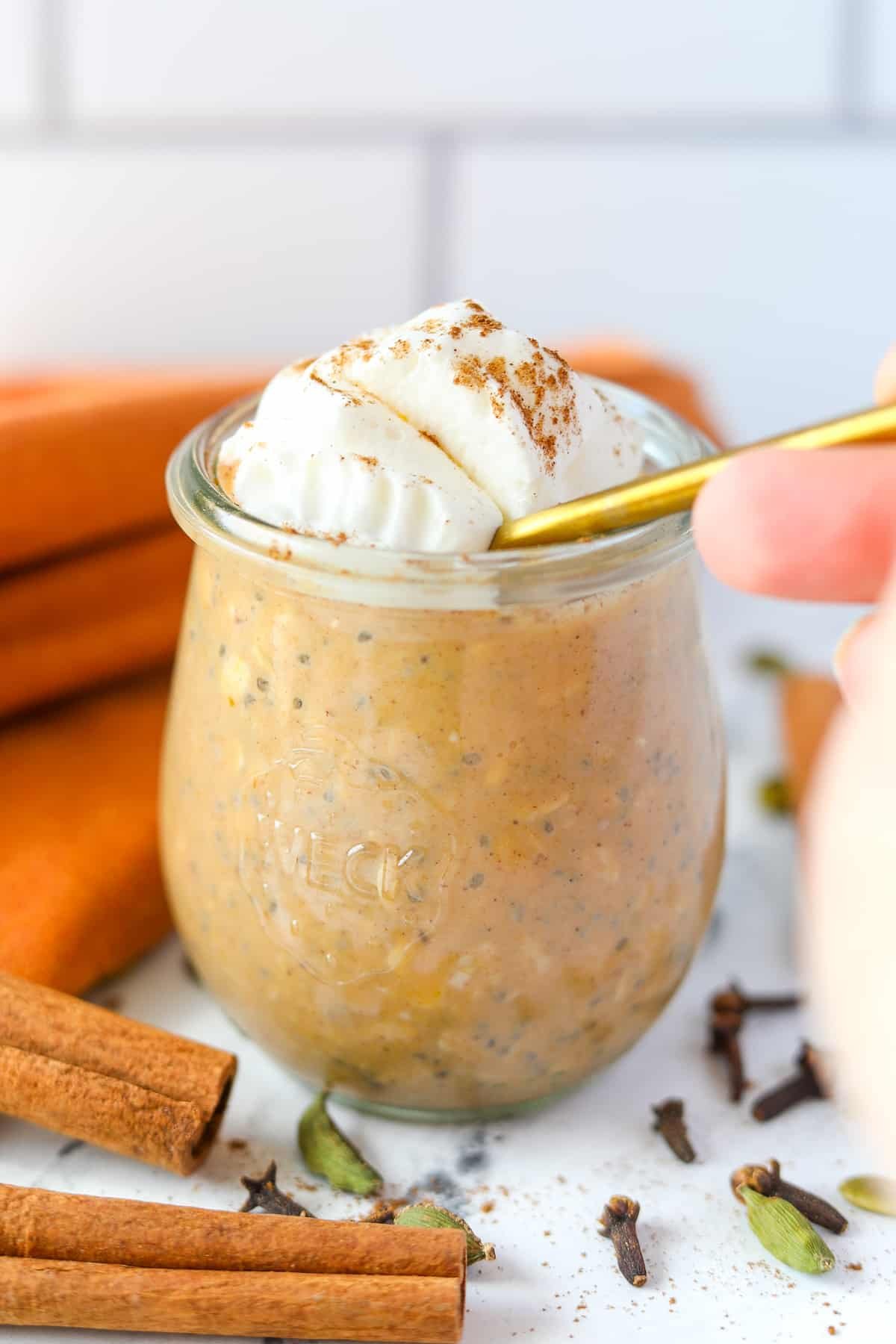 A spoon diving into a jar of overnight oats.