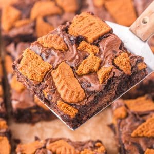 A spatula lifting a Biscoff brownie from a baking pan.