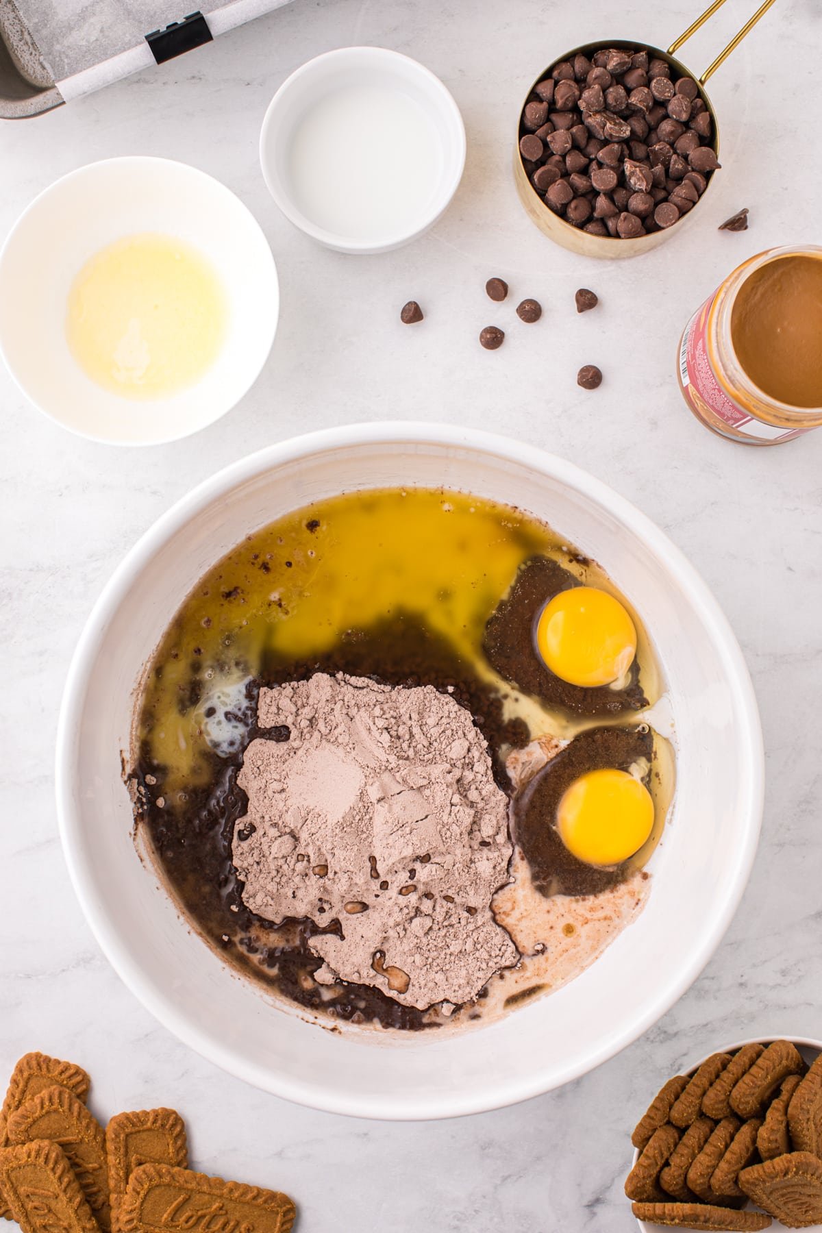 A bowl filed with brownie mix, eggs, milk, and melted butter.