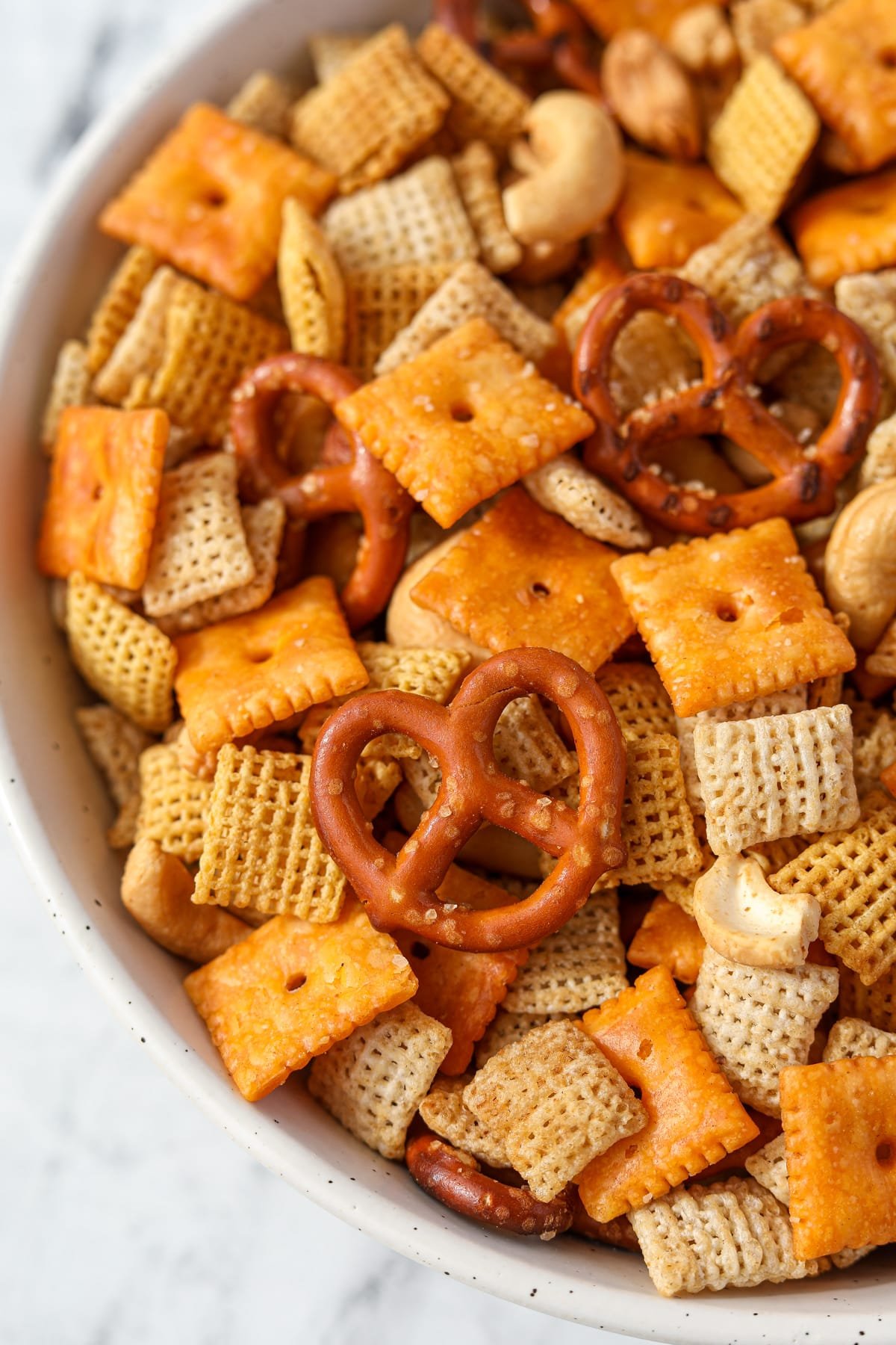 A bowl of Chex Mix with pretzels, cereal, nuts, and cheese crackers.