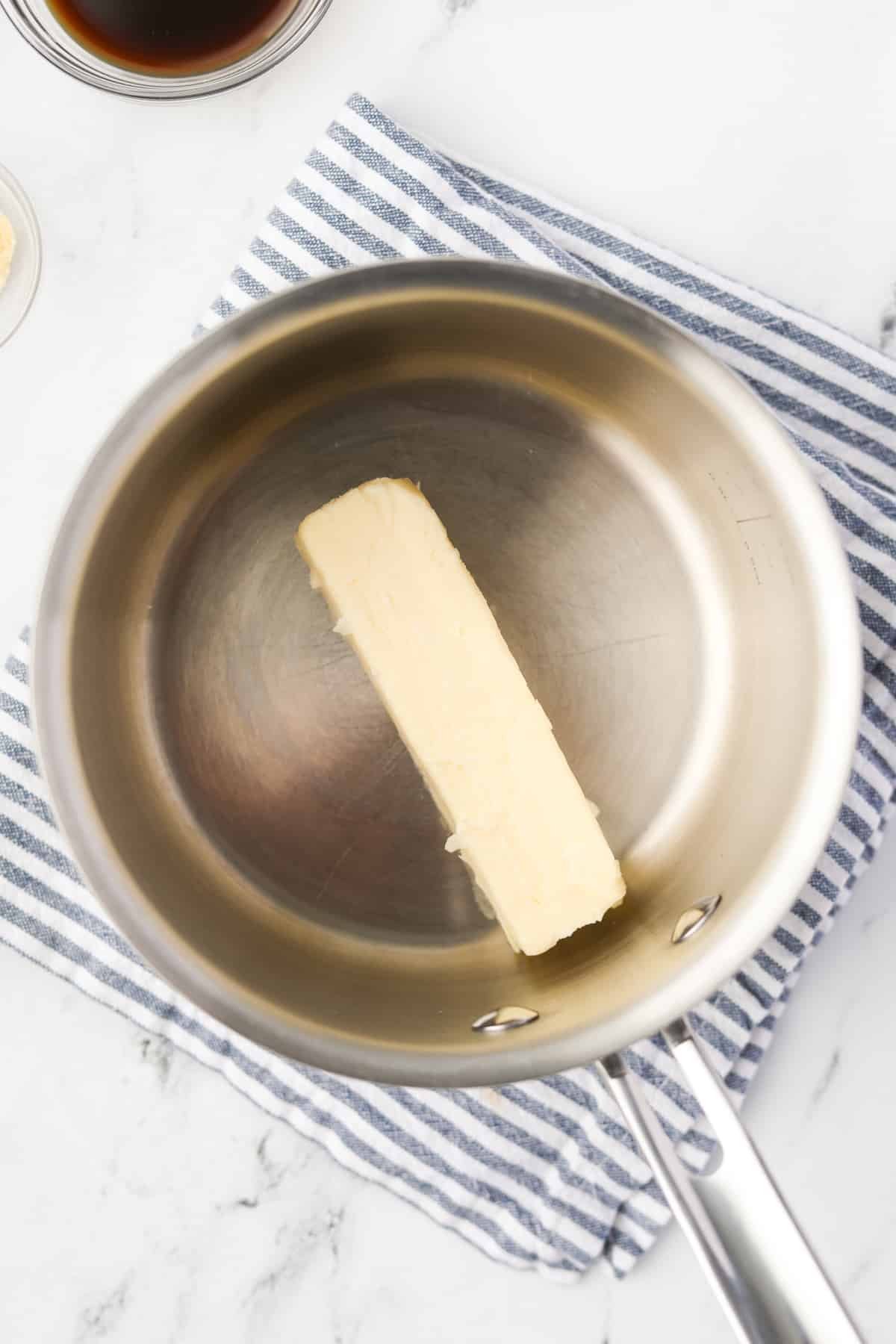A saucepan with a stick of butter in it.