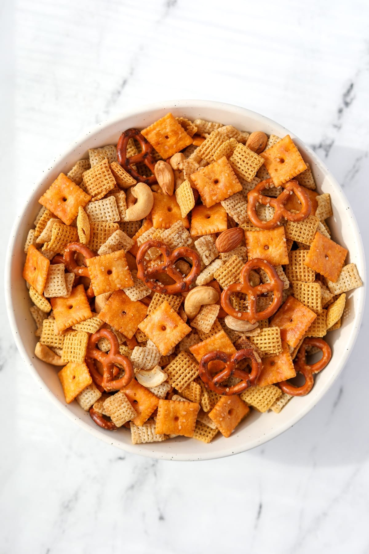 A bowl of Chex Mix on a white background.
