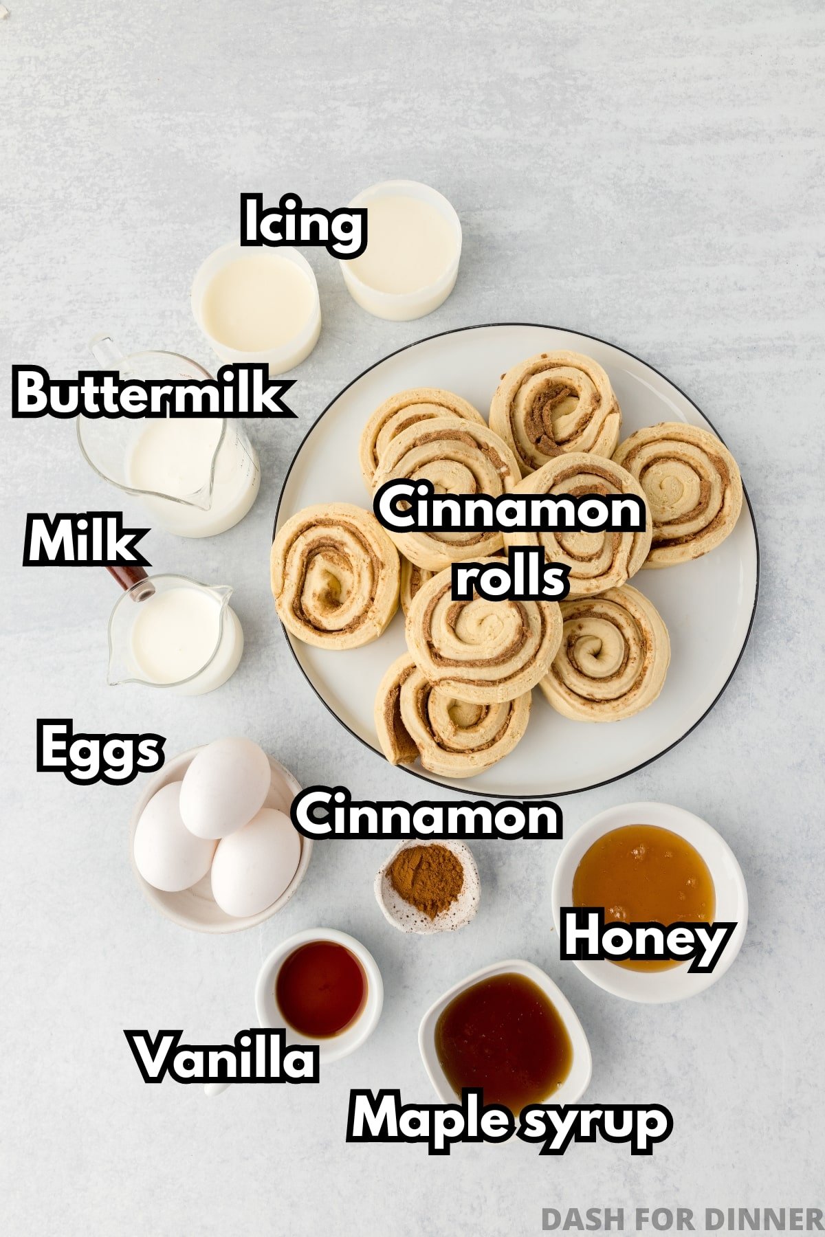 The ingredients needed to make cinnamon roll casserole: refrigerated rolls, maple syrup, honey, milk, eggs, etc.