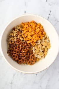 A large bowl containing pretzels, goldfish crackers, nuts, and cereal.