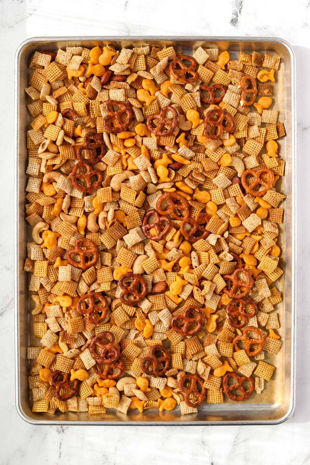 A baking pan with homemade snack mix on it.