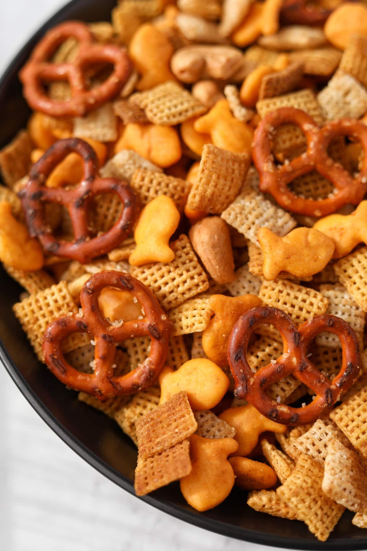 A close up of chex mix with Goldfish crackers.