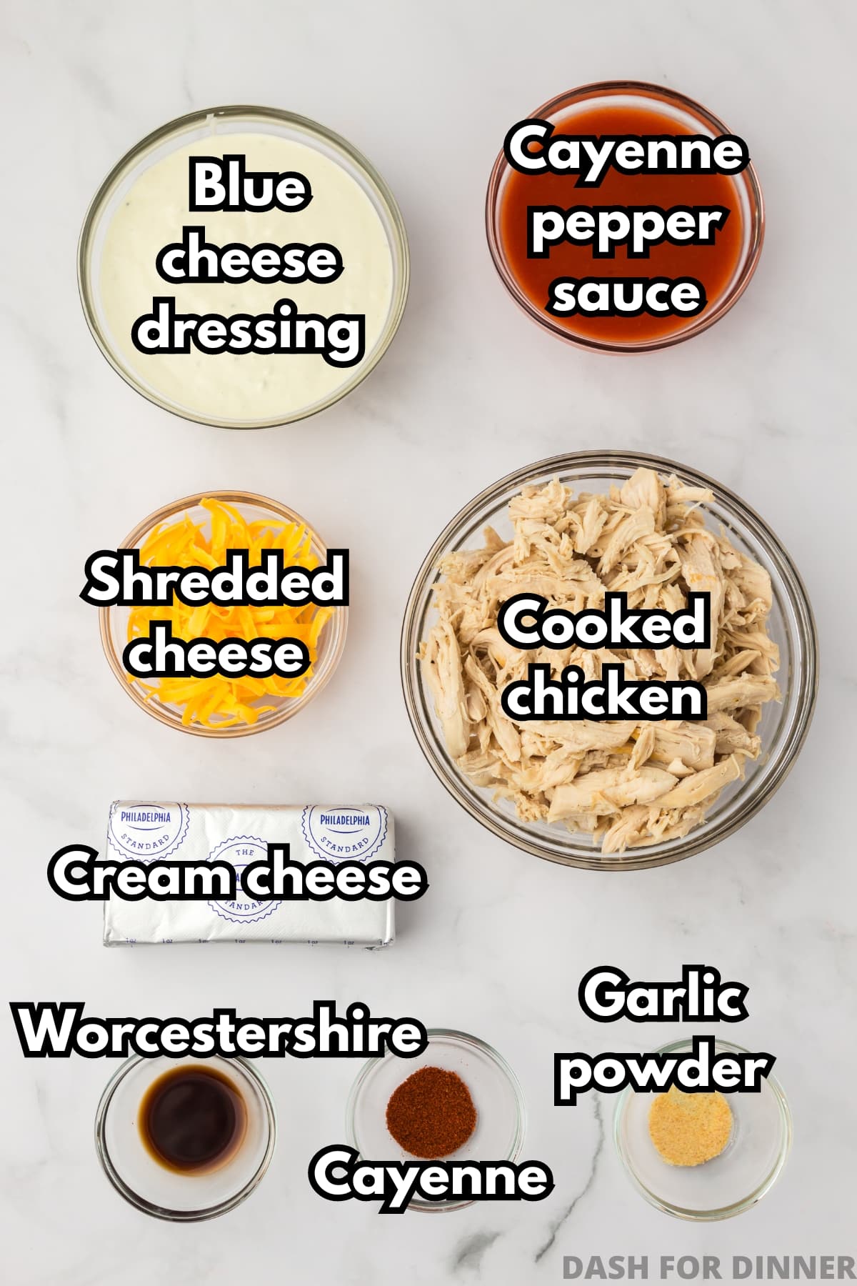 The ingredients needed to make buffalo chicken dip, including cayenne pepper sauce, blue cheese dressing, cream cheese, cheddar cheese, and cooked chicken.